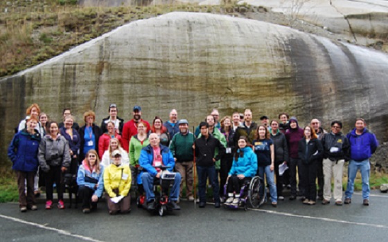 Field trip participants in front of a rock wall.