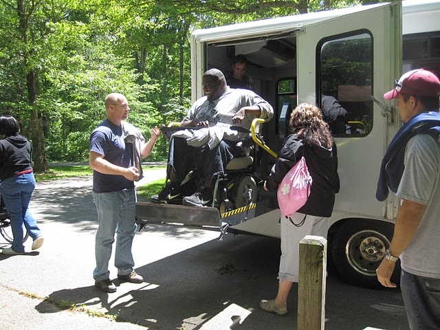 A student in a wheelchair uses the lift to exit the bus during an IAGD field trip.