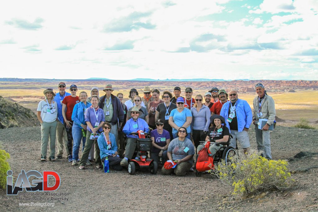 Field trip participants on a gravel overlook with a long desert vista in the background.