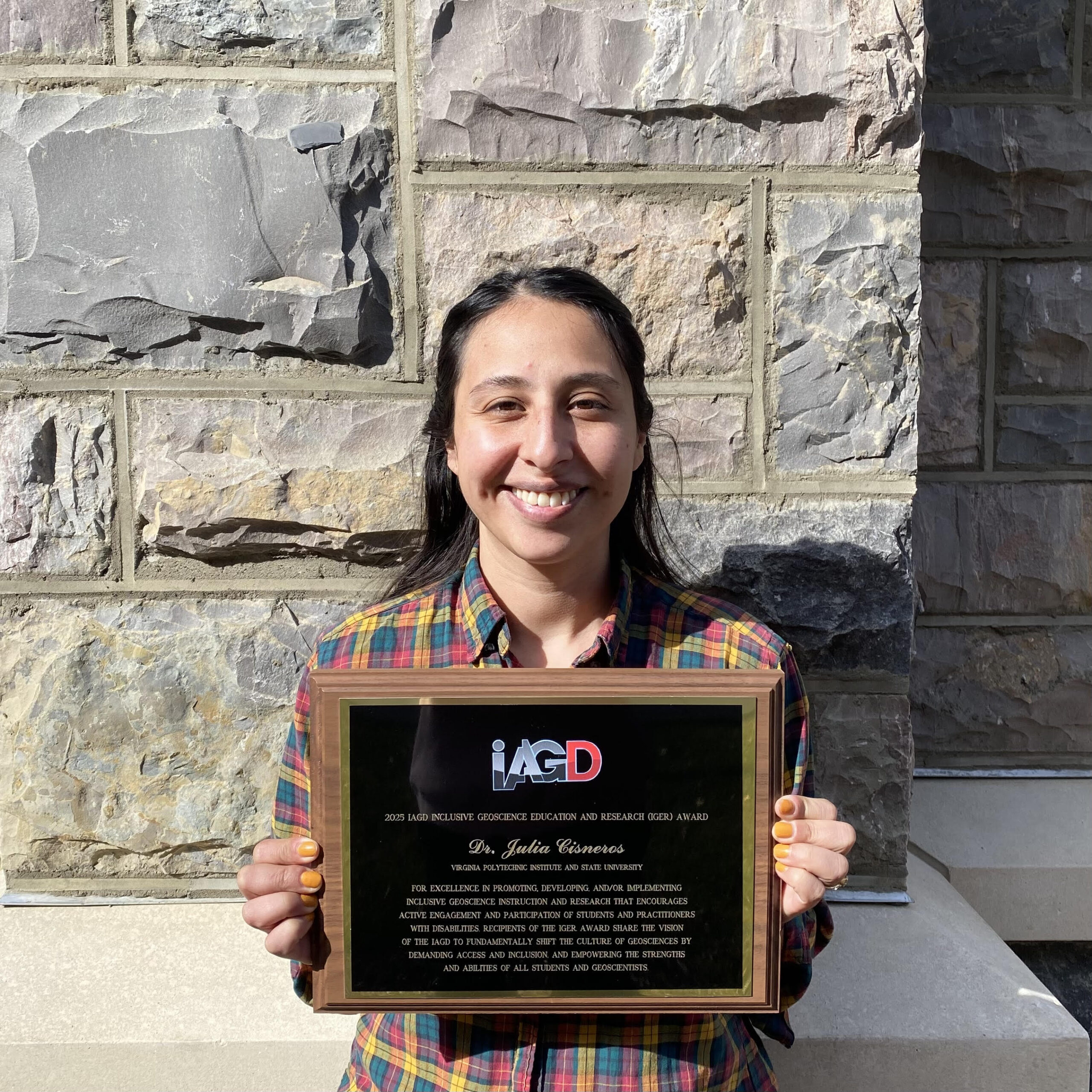 Dr. Julia Cisneros holding her IGER Award plaque