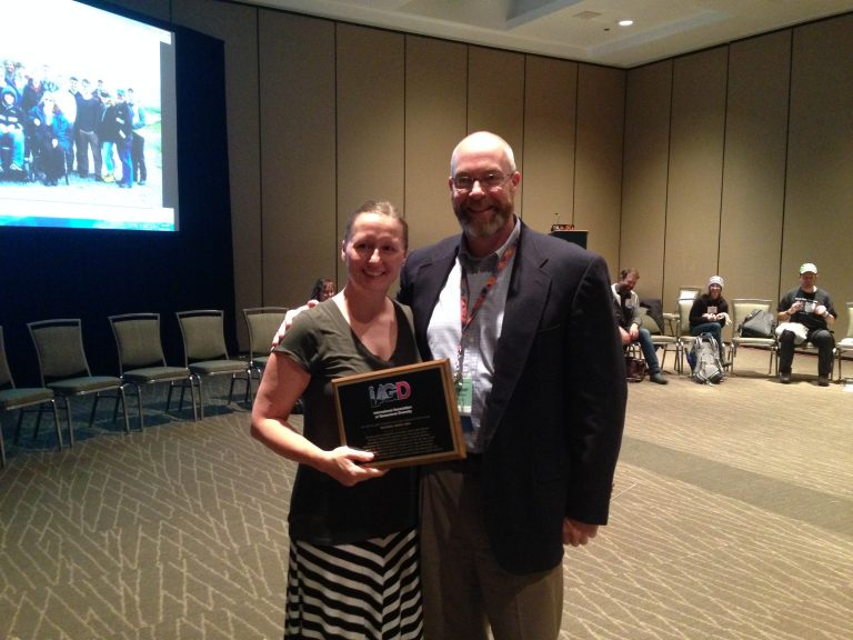 Jessica Smay holding her IGER award plaque